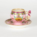 Cup and saucer with intricate enamelled and gold scroll work on a pink ground, Kornilov Factory