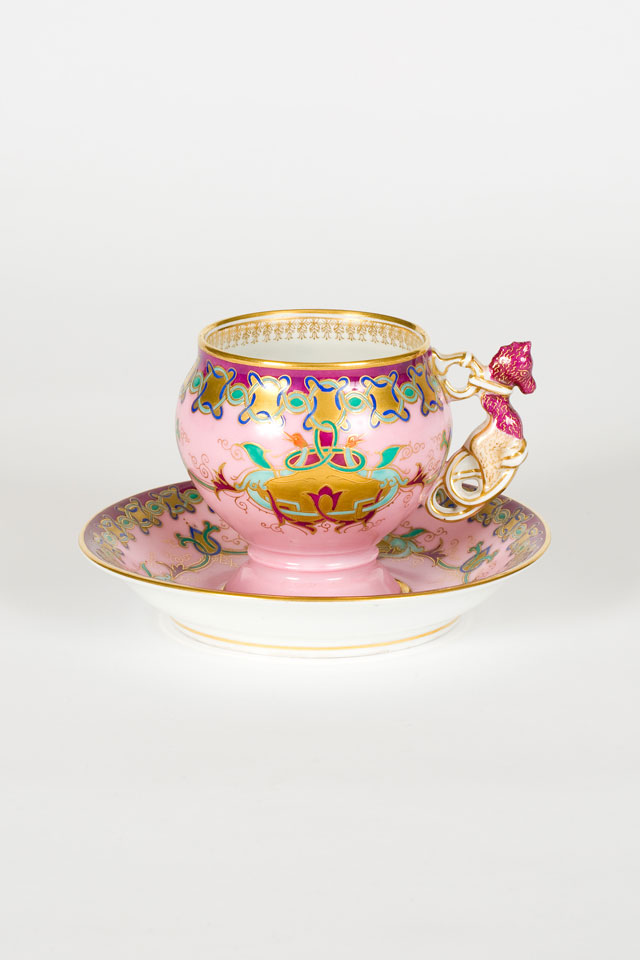 Cup and saucer with intricate enamelled and gold scroll work on a pink ground, Kornilov Factory