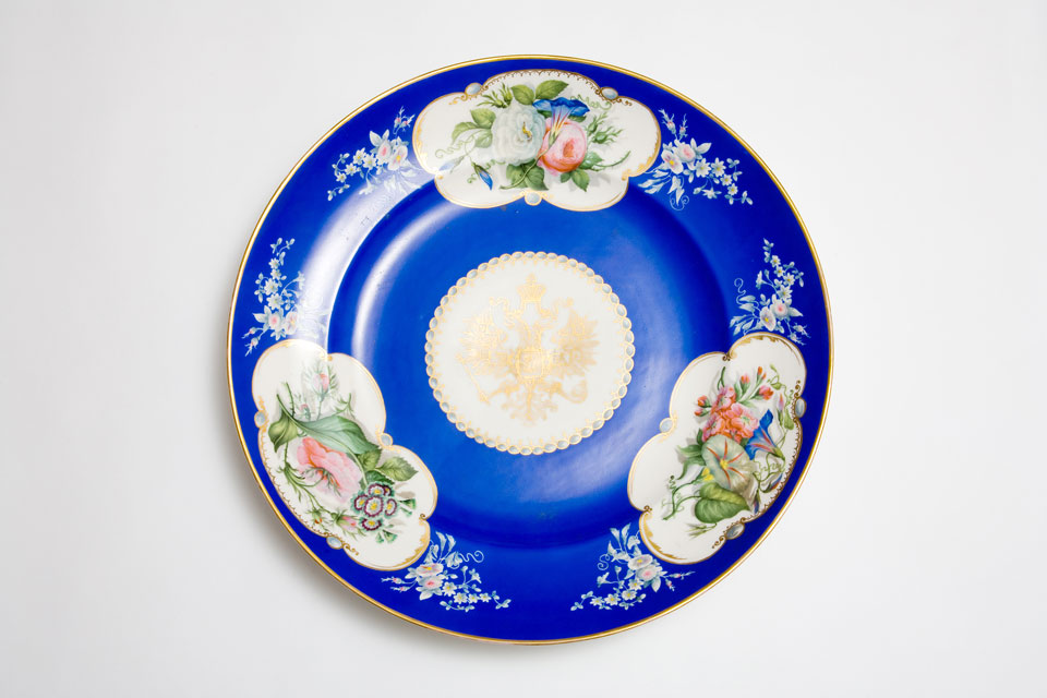 Large, circular Popov porcelain dish with gilt Russian eagle and three panels of flowers on a blue ground